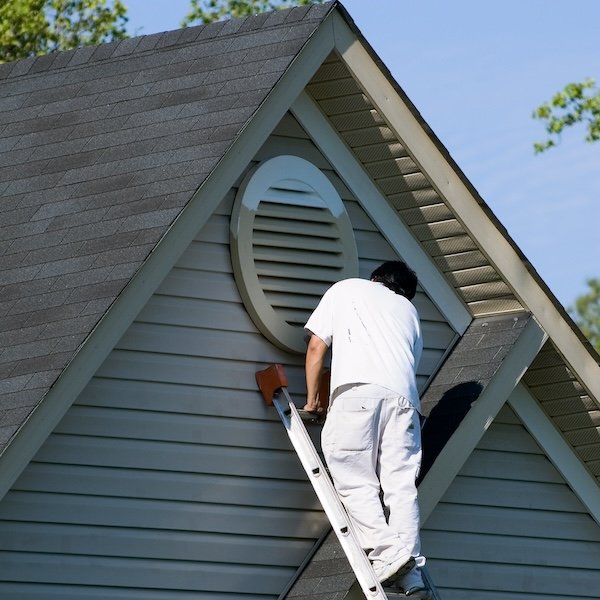 Painter painting siding of a home.